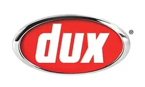 The image shows the "dux" logo, which features the word "dux" in bold white letters on a red oval background. Known among Sydney plumbers for quality, the entire design is framed by a silver metallic border.