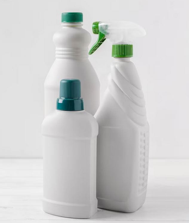 Three white plastic cleaning bottles with green lids, ideal for any household in need of a reputable plumber. One bottle has a spray nozzle, another has a flip-top cap, and the third features a twist-off cap. The bottles are arranged against a plain white background.