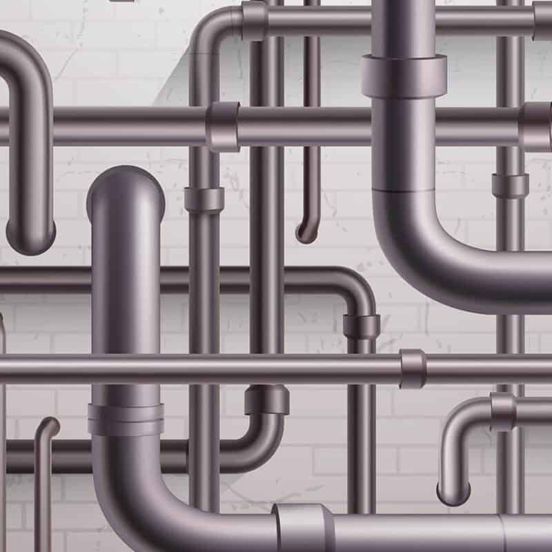 A complex network of gray metal pipes interconnected and arranged against a white brick wall. The pipes vary in diameter and include multiple curves, joints, and straight sections, resembling the intricate systems often found in resolving common running toilet issues. The scene gives an industrial and mechanical appearance.