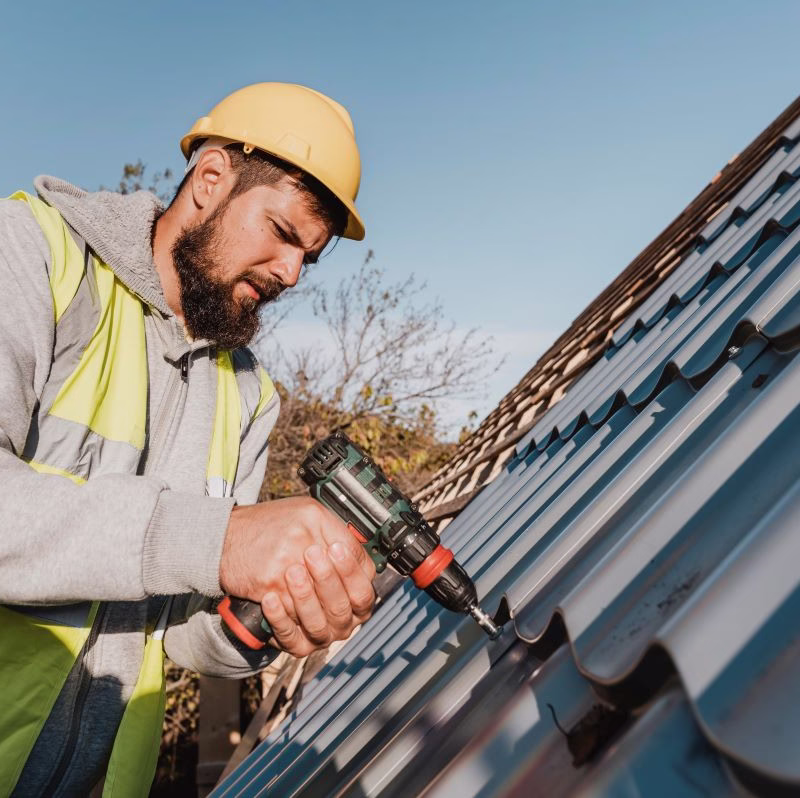 man with a drill working on a roof leak